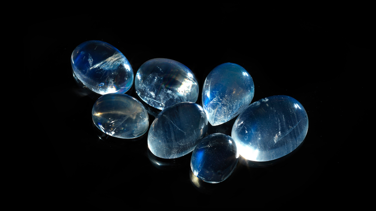 Several pieces of moonstone or set against a black background.
